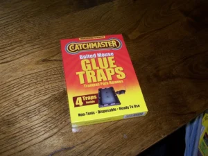 A sealed box of baited glue traps on a brown wooden table