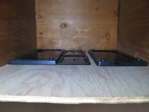 Four black glue traps in a wooden box