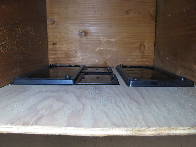 Four black glue traps in a wooden box